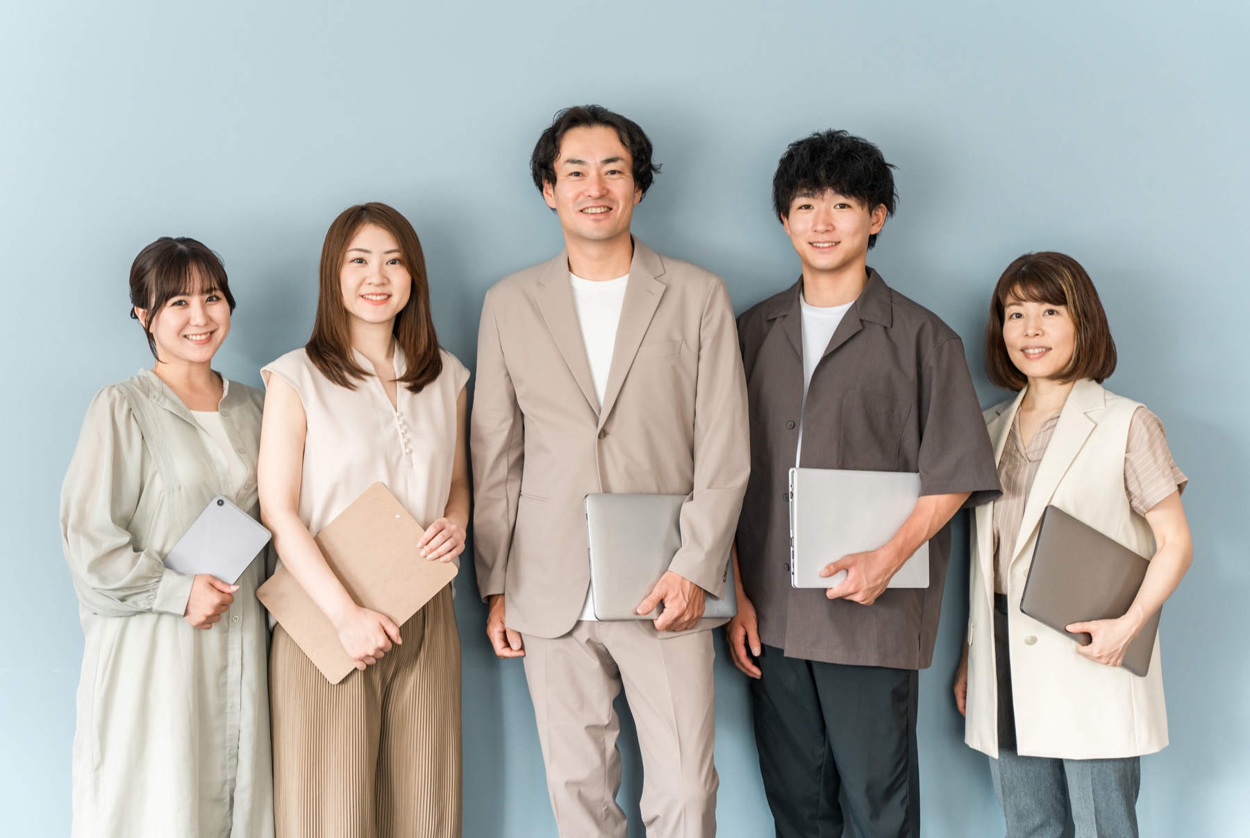 ビジネスカジュアルの服装で並ぶ男女グループ